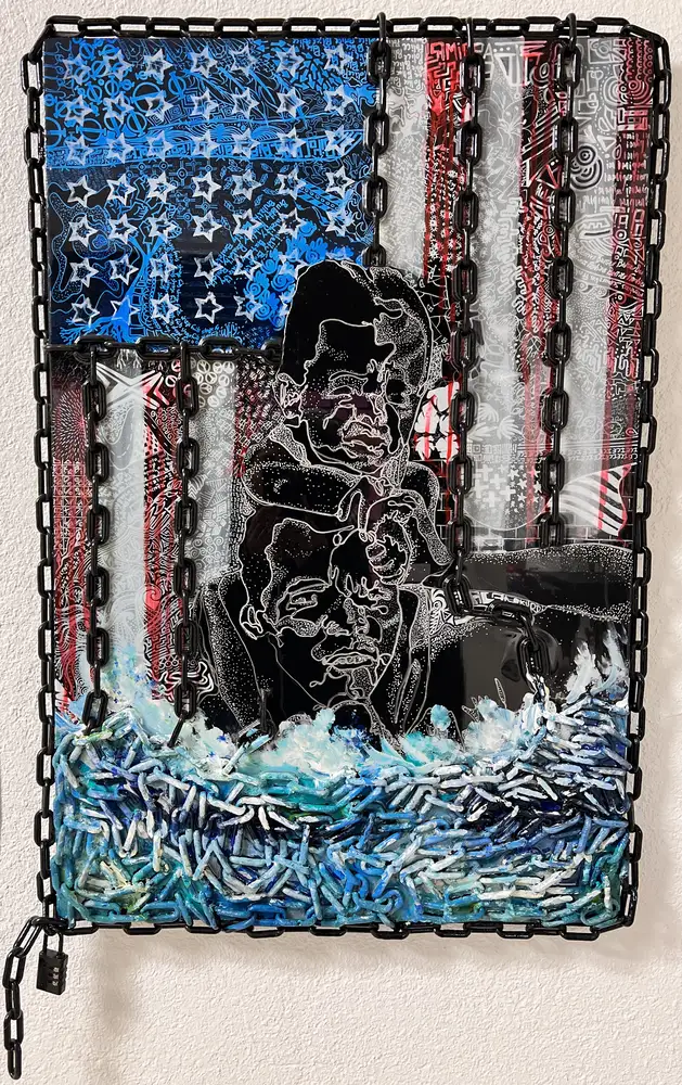 American flag built from chain over a figure, with blue and white waves of chain at the bottom
