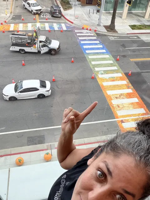 Maryam pointing down at the finished crosswalk from the library balcony