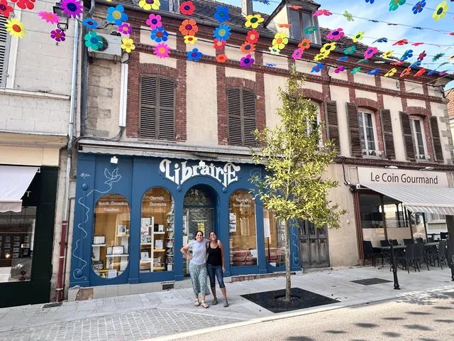 Maryam and a friend outside a French bookstore whose blue storefront she painted