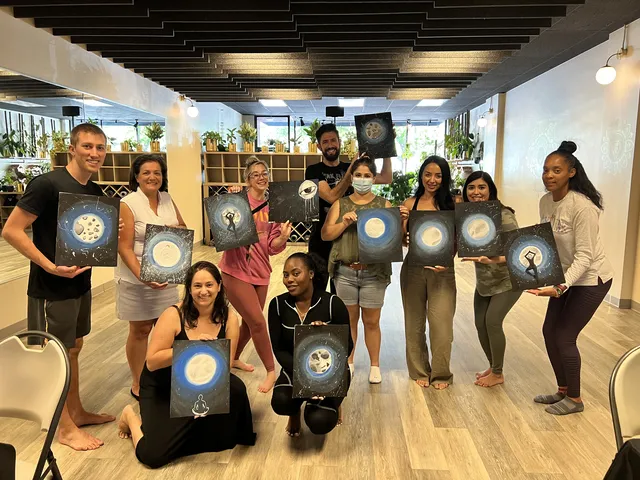 A team holding up their moon and night sky paintings