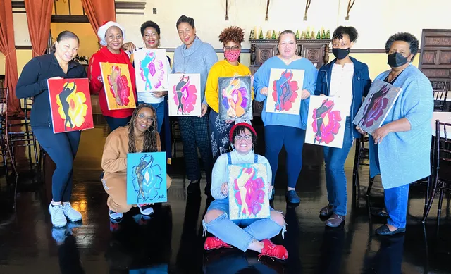 A group of adults showing their bright portrait paintings